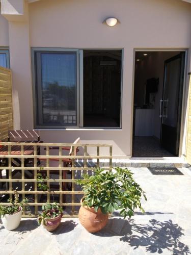 a house with potted plants on a patio at Anetis Hotel in Tsilivi