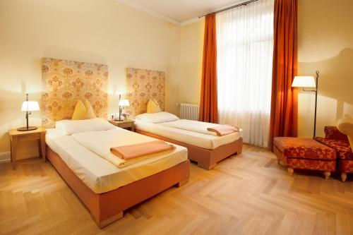 a hotel room with two beds and a window at Hotel Villa Florentina in Frankfurt