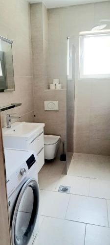 a bathroom with a shower and a washing machine at DaVita in Novalja