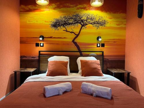 a bedroom with a bed with a tree mural on the wall at Savanaïa in Tourcoing