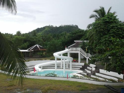 a pool with a water slide in a yard at Gazebo Pools and Restaurant in Cabadbaran