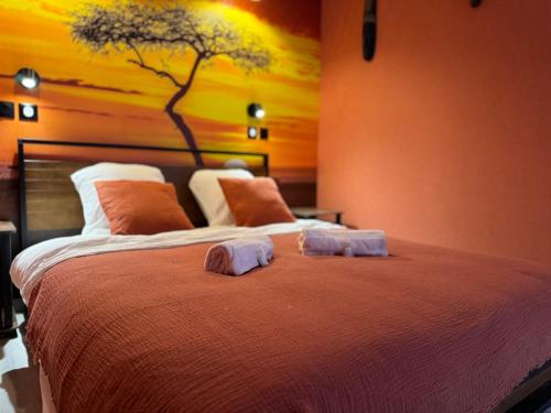 a bedroom with a bed with two towels on it at Savanaïa in Tourcoing