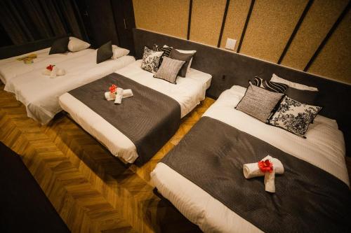 three beds in a room with candles on them at Alpha Terrace Motobu Hills in Motobu