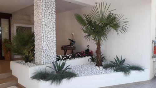 a lobby with a staircase with palm trees and rocks at Hotel Bellariva in Lido di Jesolo
