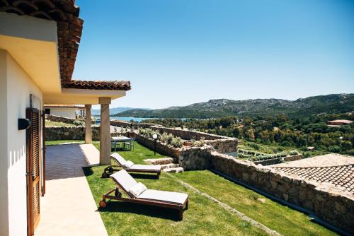 a patio with two lounge chairs on top of a house at Le Ville Le Saline in Palau