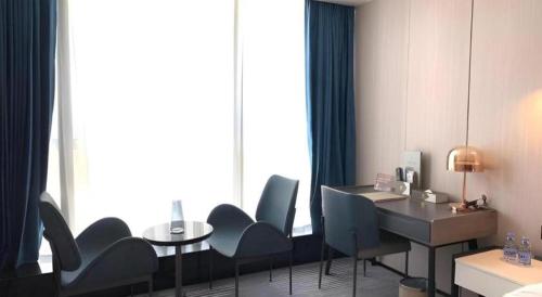 a room with chairs and a desk and a table at Golden Central Hotel Shenzhen in Shenzhen