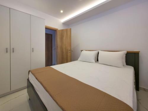 a bedroom with a large white bed in a room at ALEXANDROS apartments by SDR in Paralia Katerinis