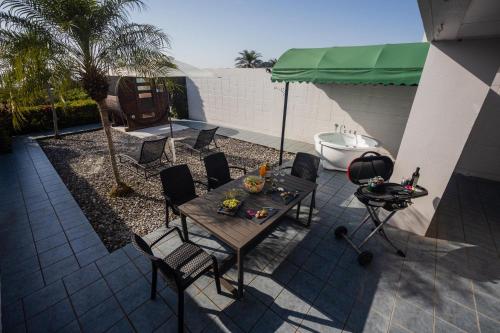 a patio with a table and chairs and a tub at Alpha Terrace Motobu Hills in Motobu