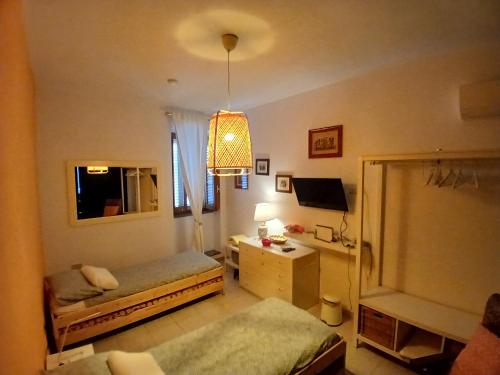 a room with two beds and a desk and a lamp at Itiseasy Cuglieri 1 e 2 Private Apartments in Cuglieri