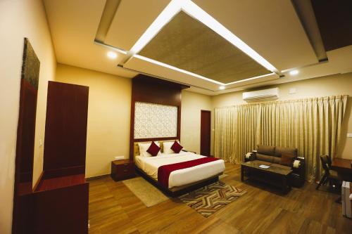 a bedroom with a bed and a chair and a couch at coral beach resort in Mahabalipuram