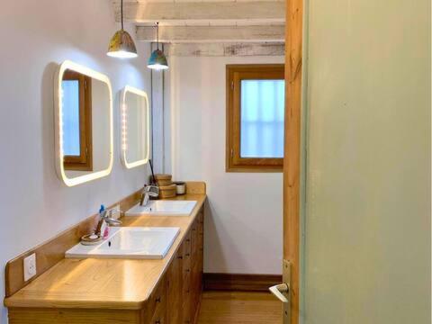 une salle de bain avec deux lavabos et deux miroirs dans l'établissement Maison Lily en Provence - Gonfaron - 4ch, à Gonfaron