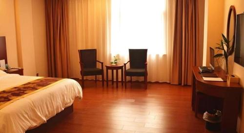 a hotel room with a bed and two chairs and a table at GreenTree Inn Anhui Xuancheng Ningguo NinGYAng East Road Darunfa Branch in Xuanzhou
