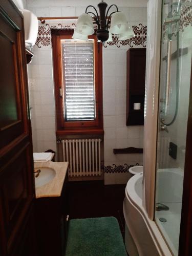 a bathroom with a sink and a toilet and a window at Villa Azzurra in Arezzo