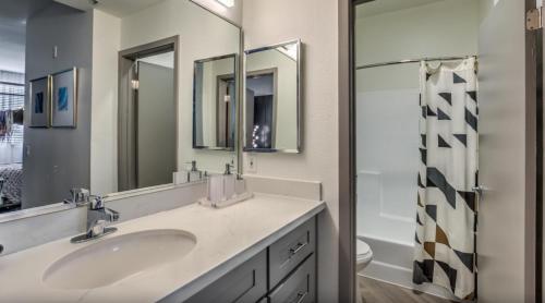 a bathroom with a sink and two mirrors at The Sherman Luxe 2 Bed Apt with FREE PARKING in Sherman Oaks Community Hospital Heliport