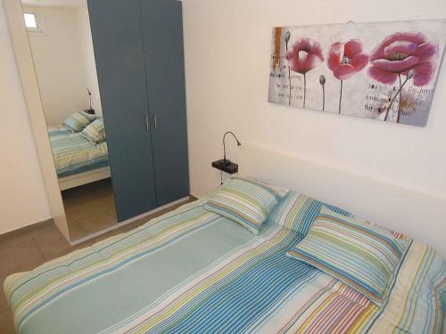 ロス・クリスティアーノスにあるCristianos Beachの鏡付きのベッドルームに枕2つ付きのベッド1台