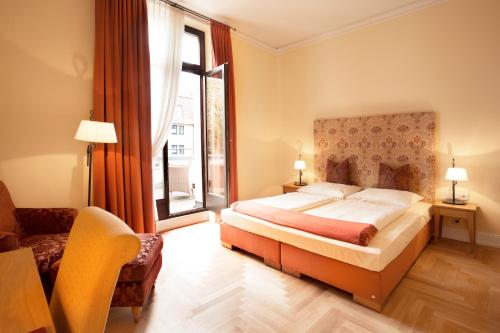 a bedroom with a bed and a large window at Hotel Villa Florentina in Frankfurt