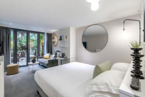 a bedroom with a white bed and a mirror at Les 2 Villas in Trouville-sur-Mer