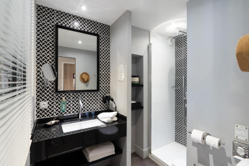 a bathroom with a sink and a mirror at Les 2 Villas in Trouville-sur-Mer