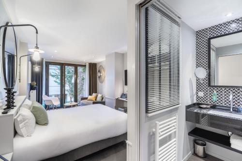 a hotel room with a bed and a mirror at Les 2 Villas in Trouville-sur-Mer