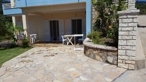 a patio with a table in front of a house at Triantis Apartments in Ligia