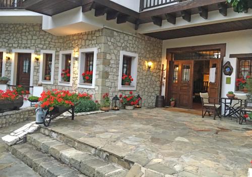a house with a stone patio with flowers on it at Hotel Ligeri in Elati Trikalon