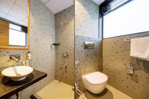 a bathroom with a toilet and a sink and a shower at Treebo Premium Niraali Executive, Hinjewadi in Pune