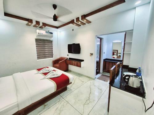 a bedroom with a bed and a mirror and a television at MARINA SUITES AIRPORT HOTEL in Cochin