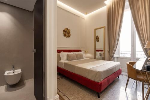 a bedroom with a bed and a table and a bathroom at Villa Libertà in Palermo