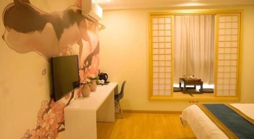 a bedroom with a bed and a desk and a window at Shell Shanghai Songjiang District Xinqiao Town Xinqiao Hotel in Chunshen