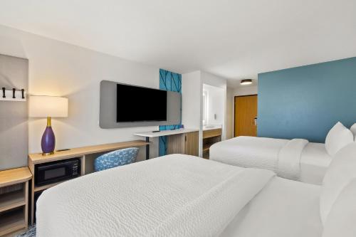 a hotel room with two beds and a flat screen tv at Sleep Inn & Suites Verona - Madison Southwest in Verona