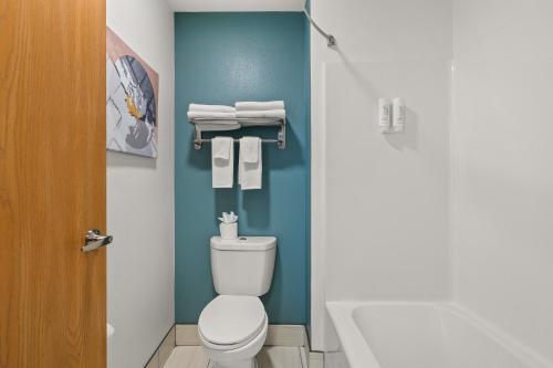 a bathroom with a toilet and towels and a tub at Sleep Inn & Suites Verona - Madison Southwest in Verona
