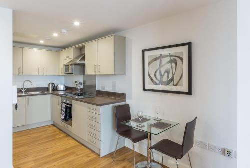 a kitchen with a table and chairs in a room at House of Fisher - 100 Kings Road in Reading