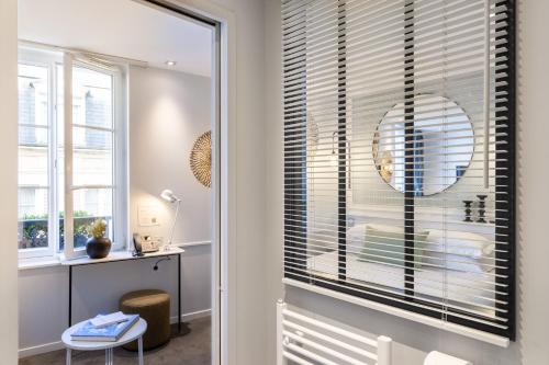 a room with a window with blinds at Les 2 Villas in Trouville-sur-Mer