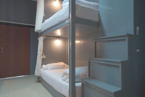 a bedroom with a bunk bed and a ladder to a bunk bed at Mee Hug Guesthouse in Phayao