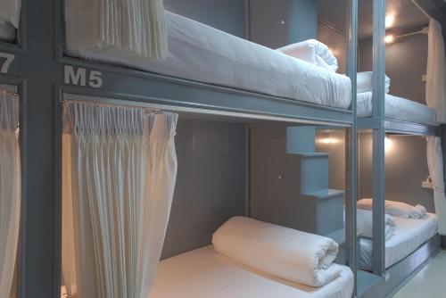 two bunk beds in a room with a mirror at Mee Hug Guesthouse in Phayao
