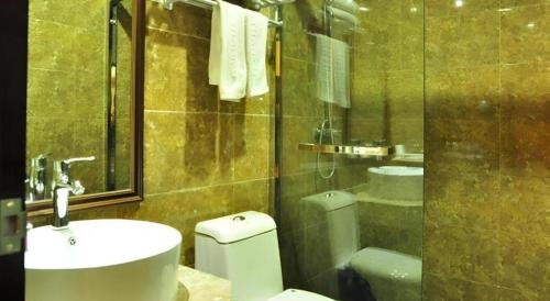 a bathroom with a toilet and a sink and a shower at Thank Hotel Jiangxi Jiujiang Lianxi District Railway Station Square in Jiujiang