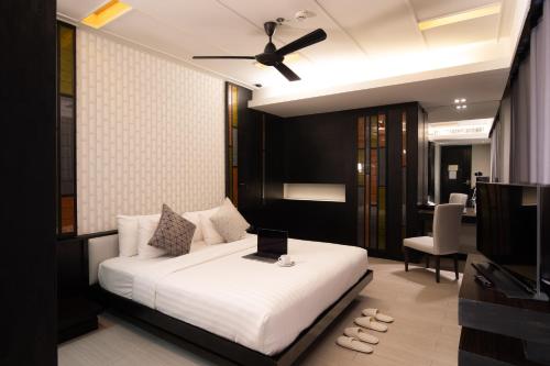a bedroom with a bed with a laptop on it at De Chai Oriental Nimman - SHA Plus in Chiang Mai