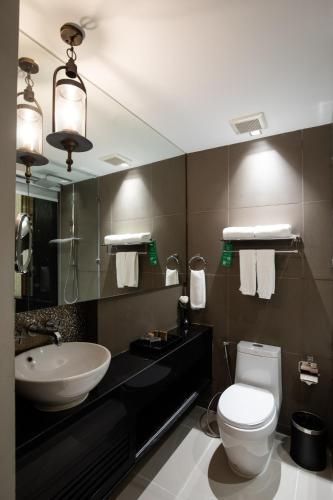 a bathroom with a white toilet and a sink at De Chai Oriental Nimman - SHA Plus in Chiang Mai
