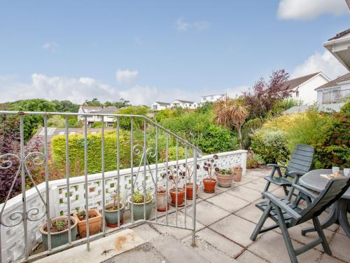 a balcony with a table and chairs and potted plants at Leighwood Cottage in Paignton