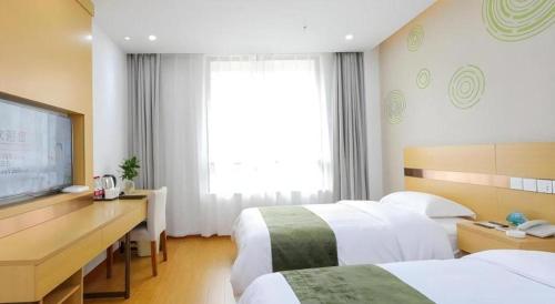 a hotel room with two beds and a desk at GreenTree Inn Jiaxin Puyuan Kaixuan Road in Jiaxing