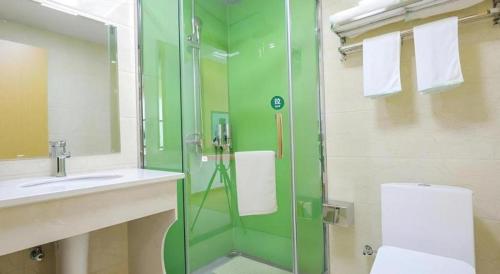 a bathroom with a glass shower and a sink at GreenTree Inn Jiaxin Puyuan Kaixuan Road in Jiaxing