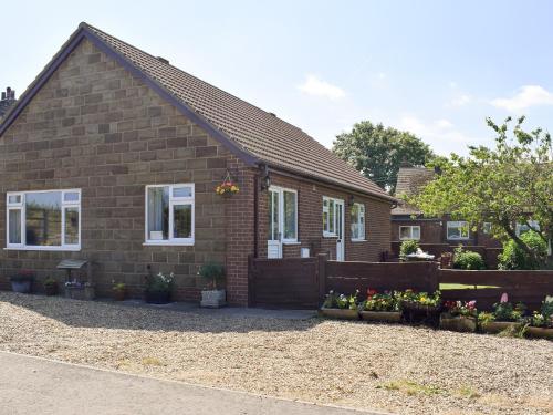 a brick house with flowers in front of it at Cherrytree Cottage in Loftus