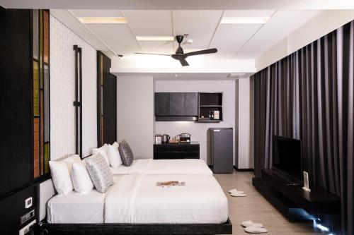 a hotel room with a bed and a ceiling fan at De Chai Oriental Nimman - SHA Plus in Chiang Mai