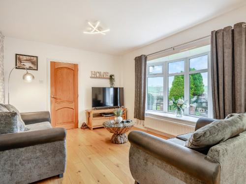a living room with two couches and a large window at Delcroft in Drybrook