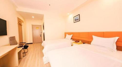 a hotel room with two beds and a desk at 7 Days Inn Harbin Medical University First Affiliated Hospital in Harbin