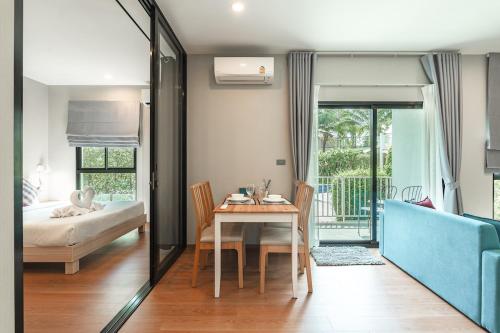 a dining room with a table and a bedroom at C222 Cozy 1BR Condo with Pool Access 500 m to Beach in Rawai Beach