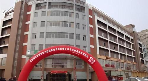 a large building with a red arch in front of it at GreenTree Inn Gaoyou Government in Yangzhou