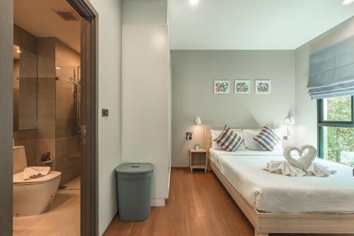 a white bedroom with a bed and a bathroom at C222 Cozy 1BR Condo with Pool Access 500 m to Beach in Rawai Beach