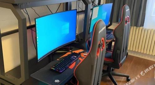 a desk with two computer monitors and a keyboard at Jinjiang Inn Qingdao Wuxi Square Nanjing Road Metro Station in Qingdao