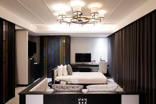 a hotel room with a bed and a desk at De Chai Oriental Nimman - SHA Plus in Chiang Mai